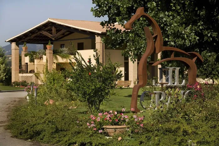 Scultura di cavallo in metallo con la scritta Il Baio davanti al portico d'ingresso