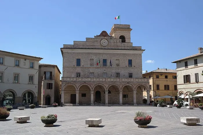 The town hall of Montefalco with its arcade and clock tower on the square