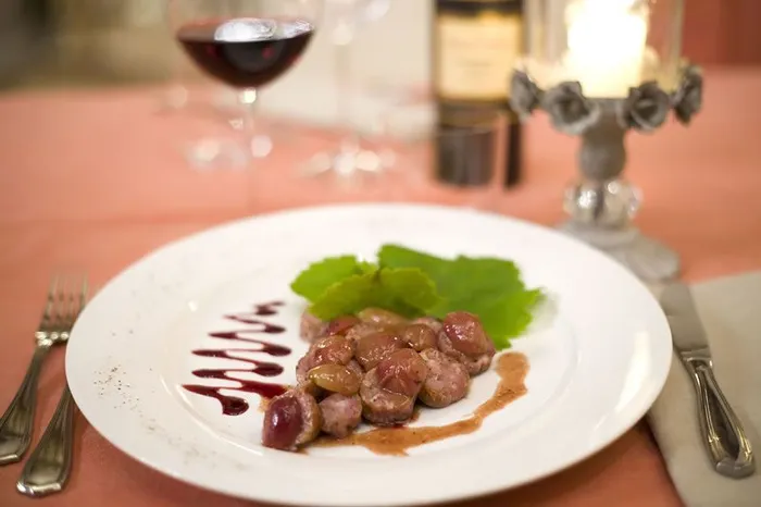 Bocconcini di carne con uva e riduzione scura, serviti a lume di candela