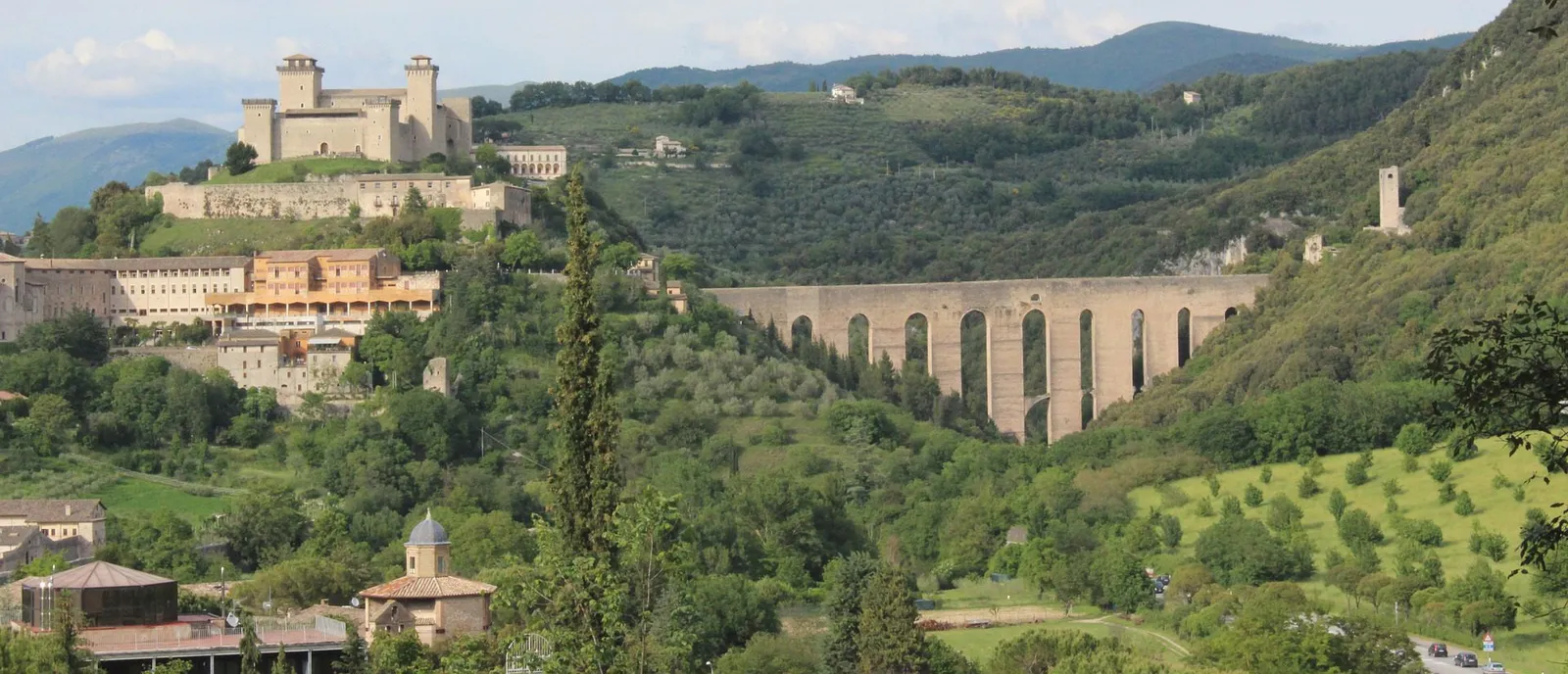 View of Spoleto with the fortress on its hill and the arched bridge in the woods